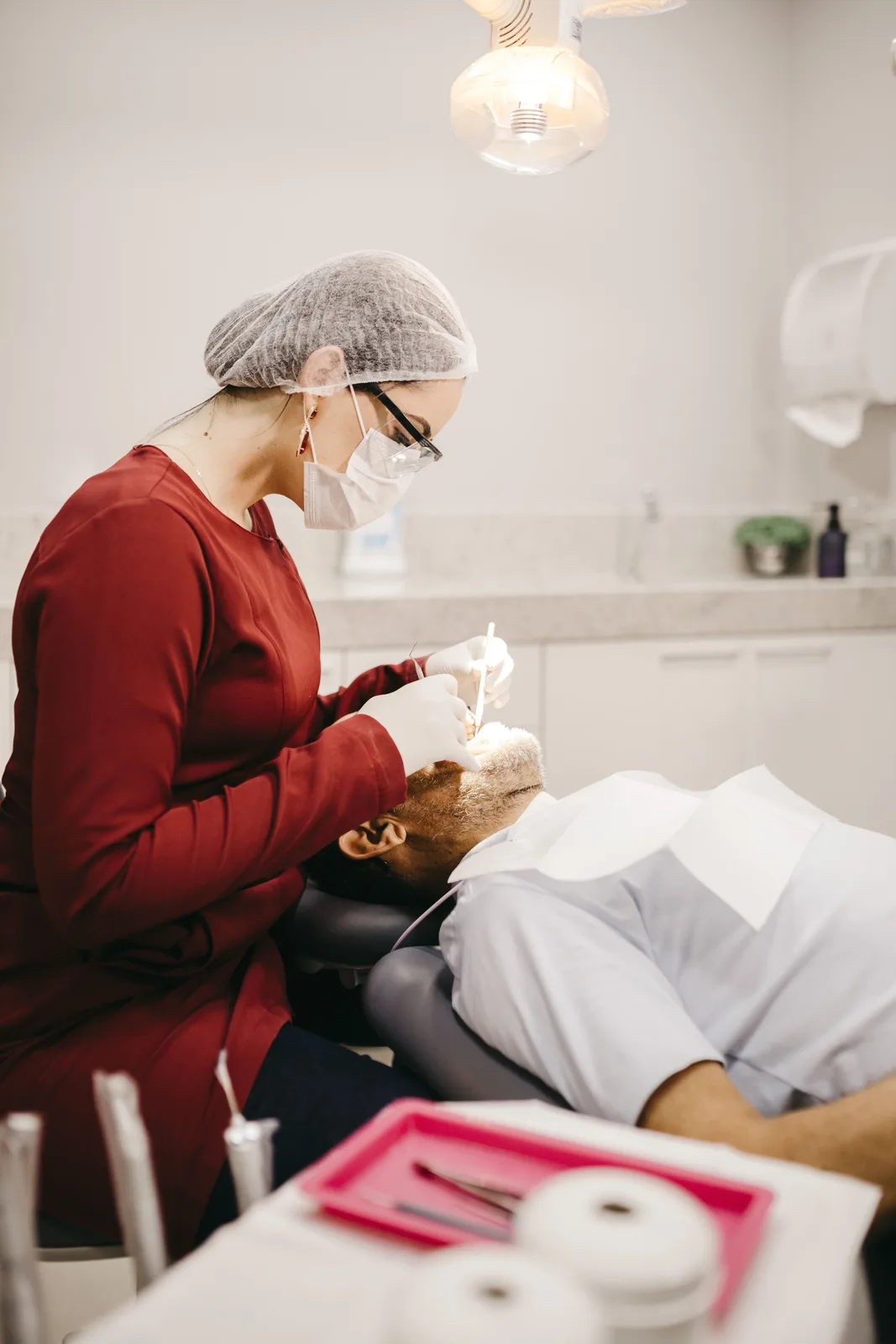 Dentist working under the operatory light, referred to in the Implant Procedures section for Victoria