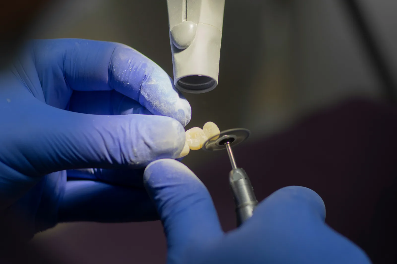 Technician finishing an implant crown in the laboratory, for multiple tooth implants in Victoria