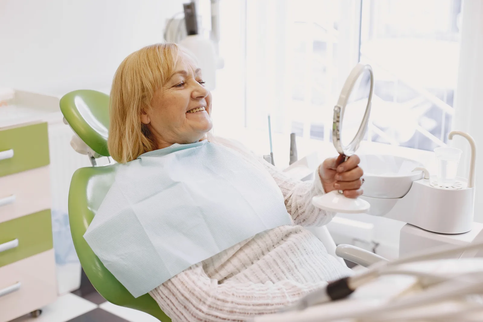Patient reviewing a new smile in the mirror, shown while covering Full Mouth Cost in Victoria